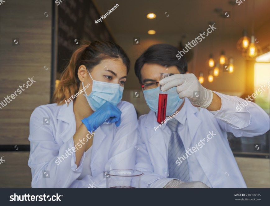 stock-photo-portrait-of-woman-and-man-mask-medical-glove-research-scientist-or-doctor-looking-at-a-test-tube-718908685